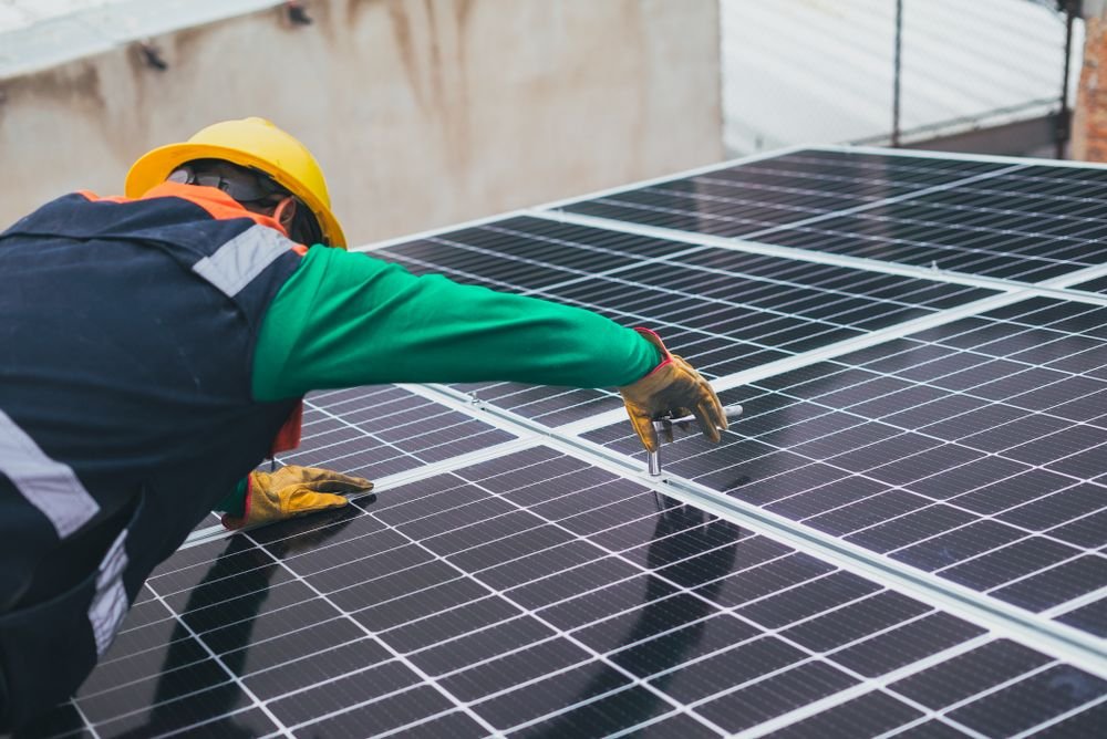 Technician performing solar panel maintenance and inspection in Iraq